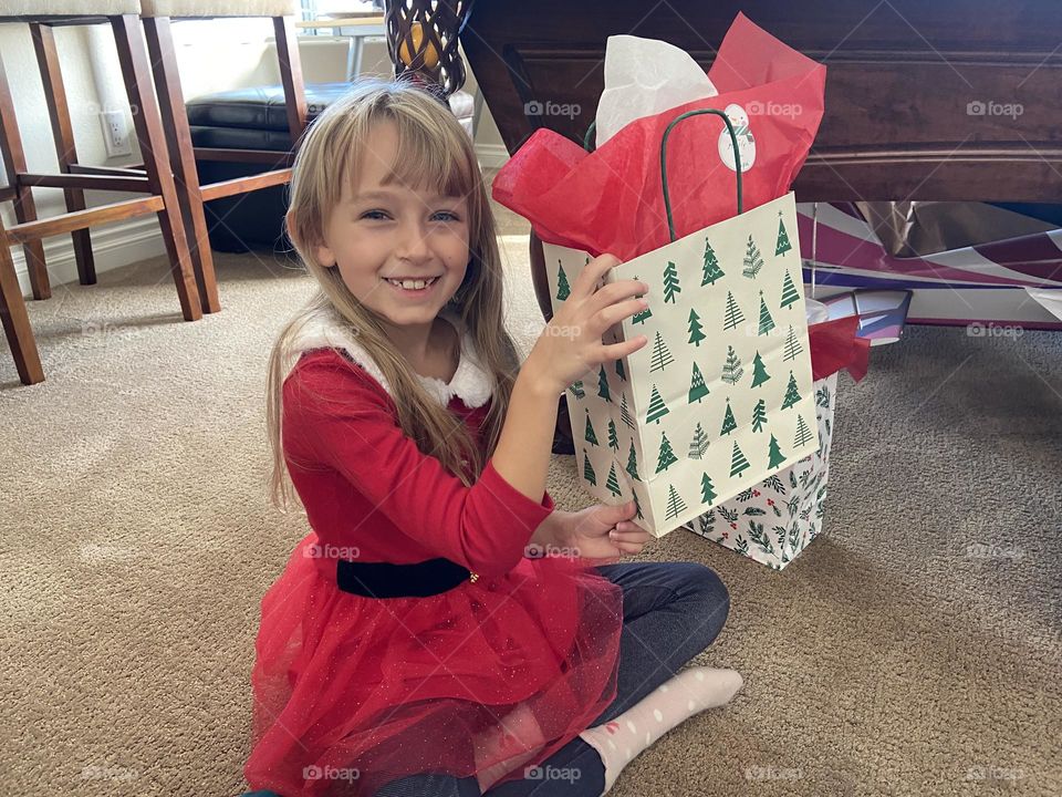 Little girl opens gifts wearing Santa dress 