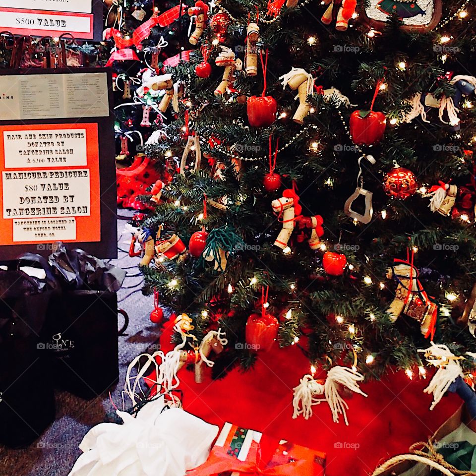 A beautiful Christmas tree with red apple and horse ornaments on display indoors for the holiday season. 