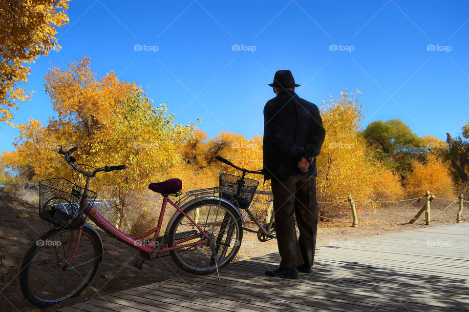 An old man admires the beautiful scenery as he seems to be wondering about where is his old lady