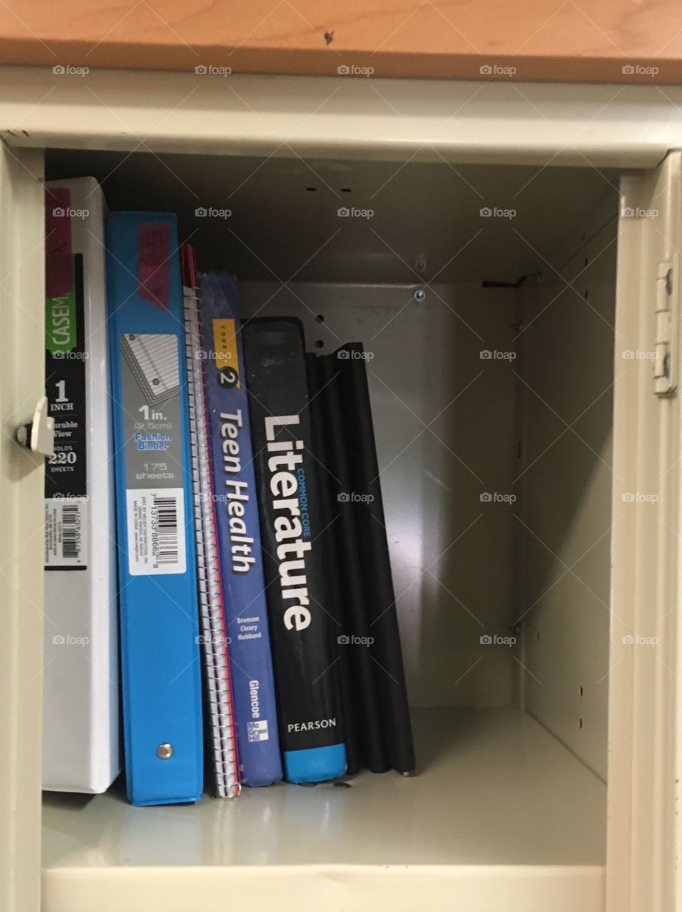 Open locker, top shelf, textbooks and binders