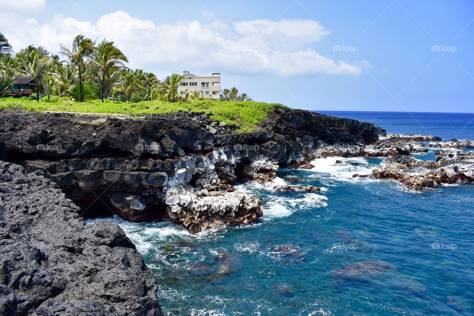 Beautiful ocean with homes along the sea cliff on the east side of the Big Island of Hawaii.