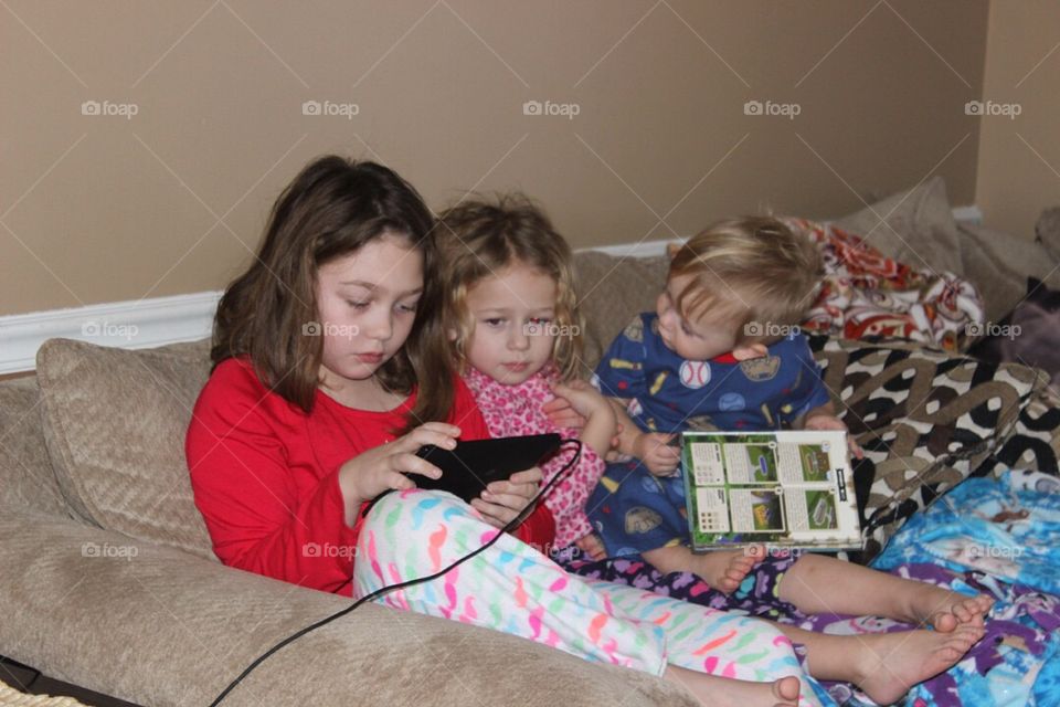 Cute little siblings sitting on couch