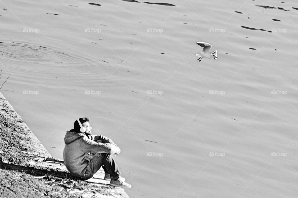 man listening music on the riverside