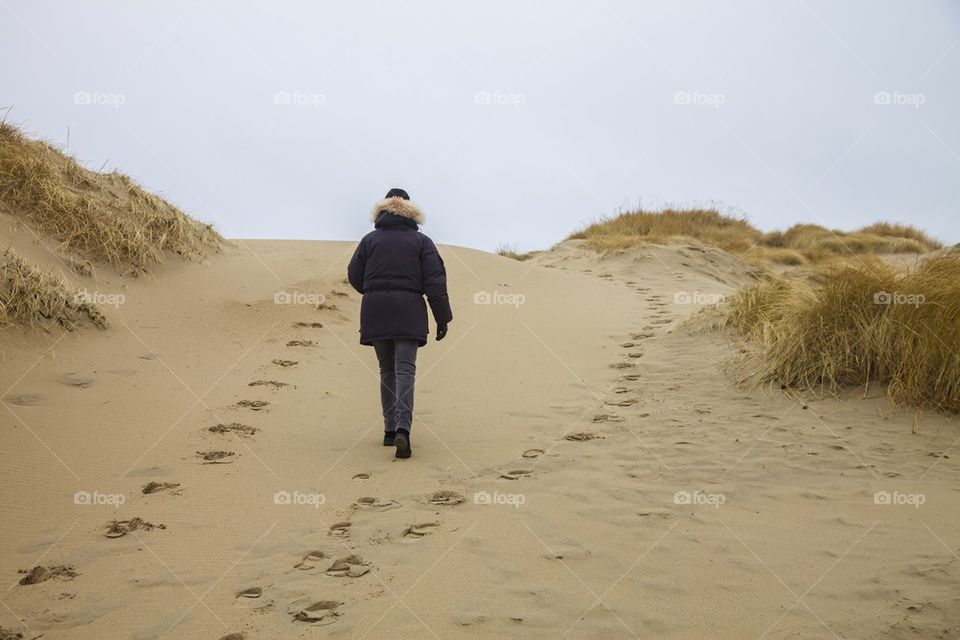 Woman walking in sand.