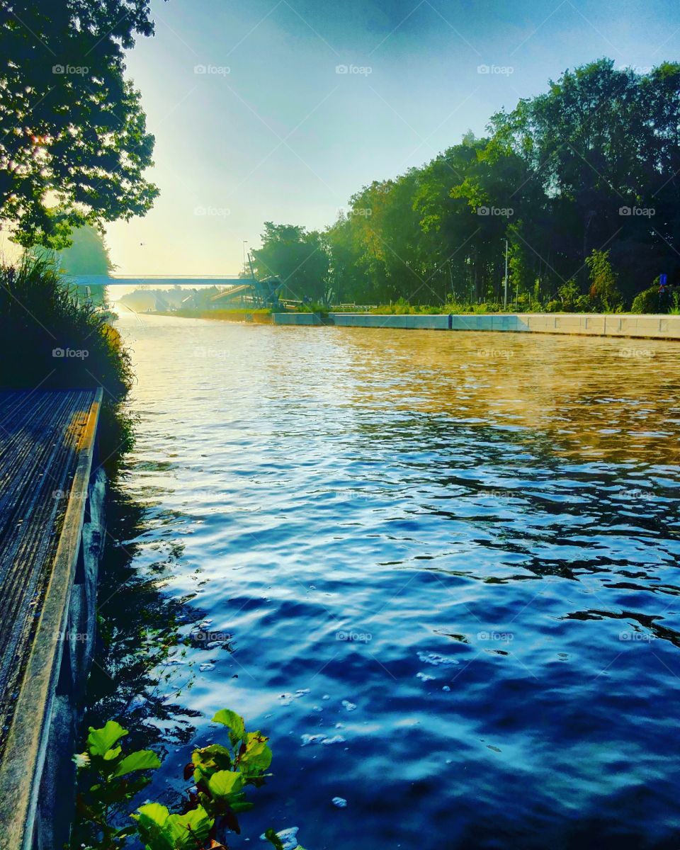 Golden sunrise over the water of a river, creating an idyllic and Tranquil scenic landscape 