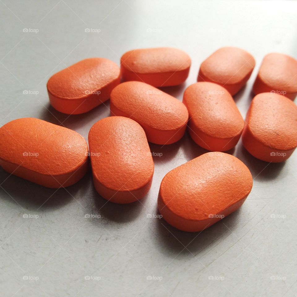 pharmaceutical tablet and medicine in orange color is on table for treatment