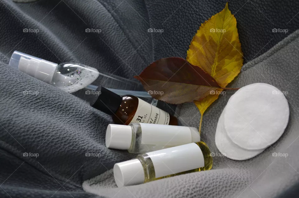 Jars with cream, shampoo and cosmetics on a background with autumn leaves