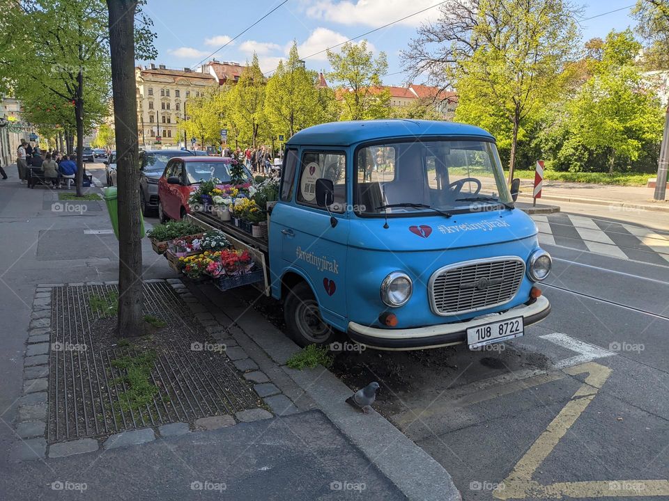 A cute little truck with flowers on the street in Prague.