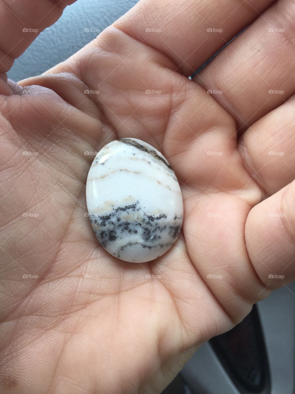 Grey White Tan Oval Stone Cabochon in palm of Hand 
