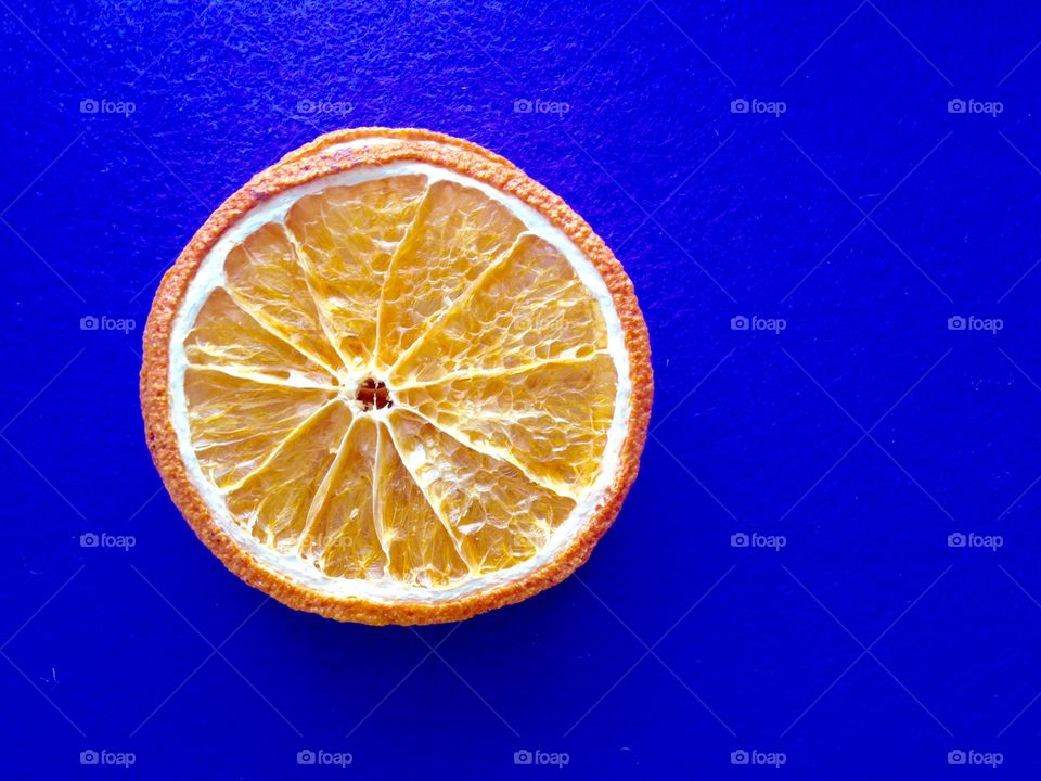 Dry citrus slice on a violet background.