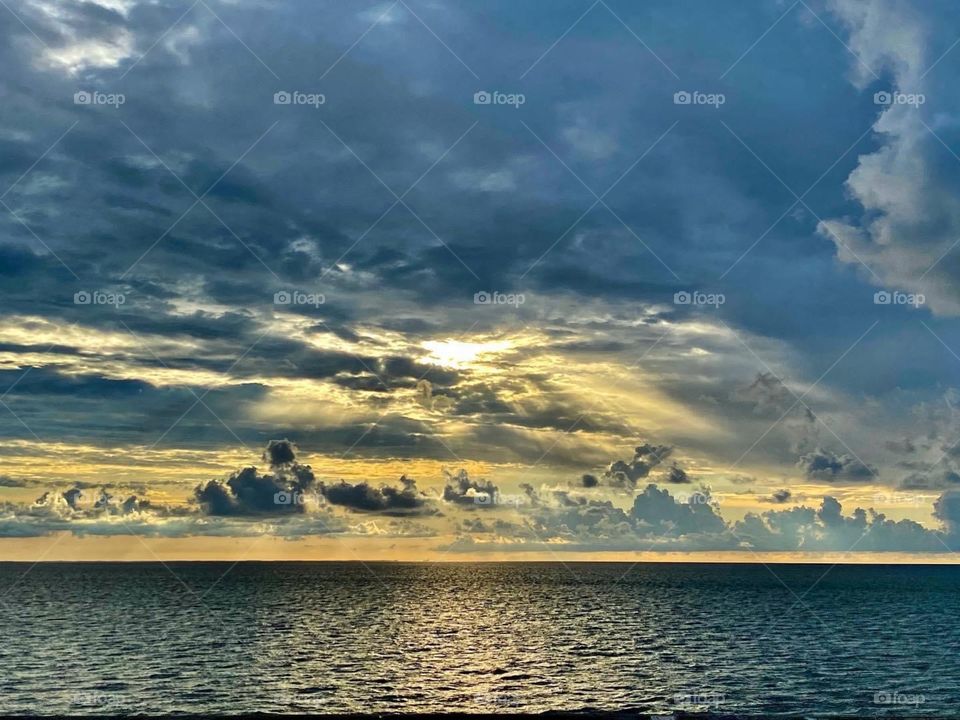 Sunrise over water with clouds
