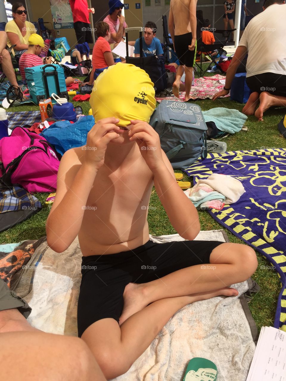 Boy with swimming cap over his head