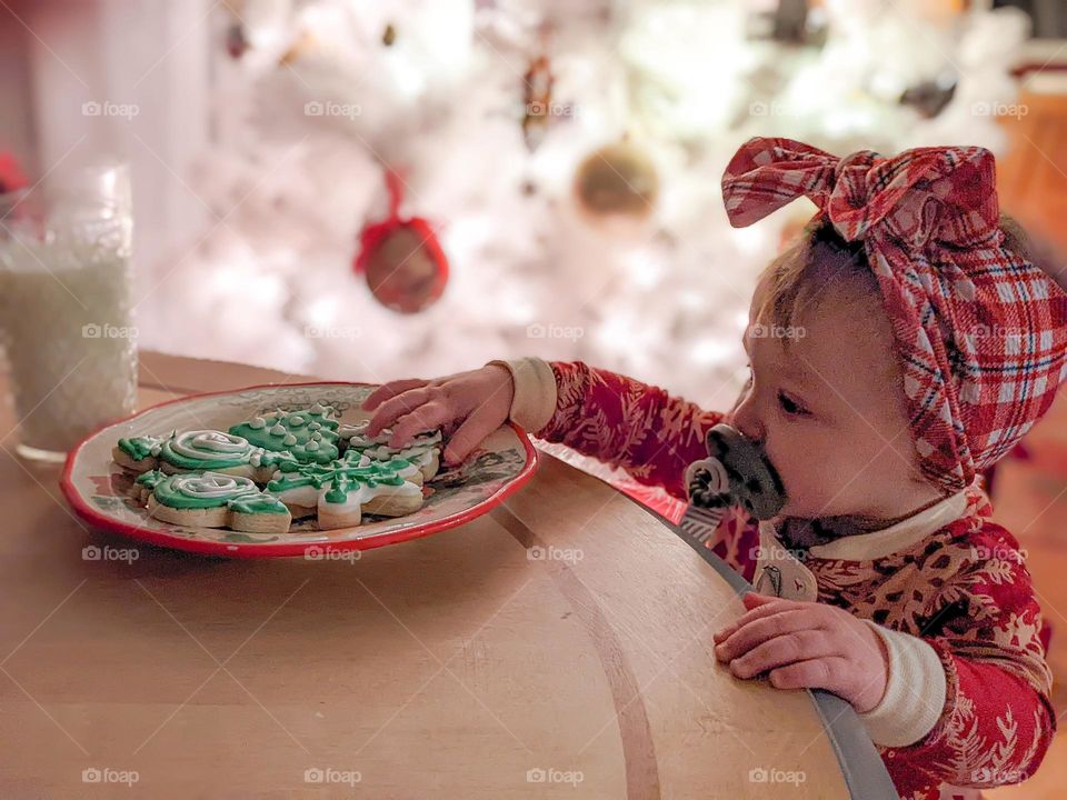 Baby reaches for Santa's cookies