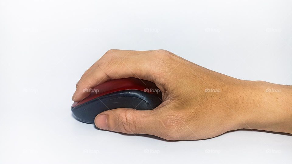 Person's hand holding a mouse on an isolated white background in eye level view