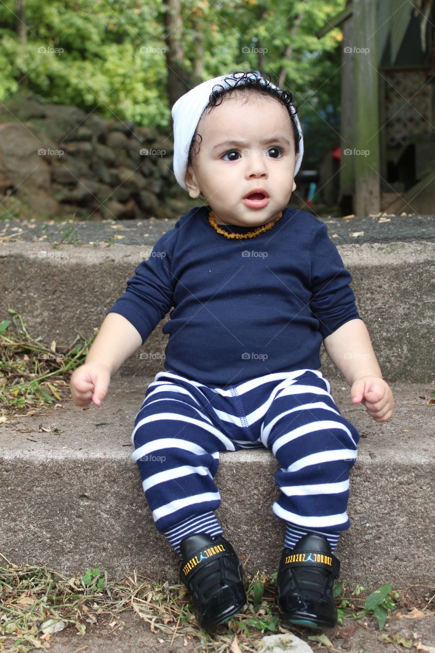 Cute boy sitting on staircase at park