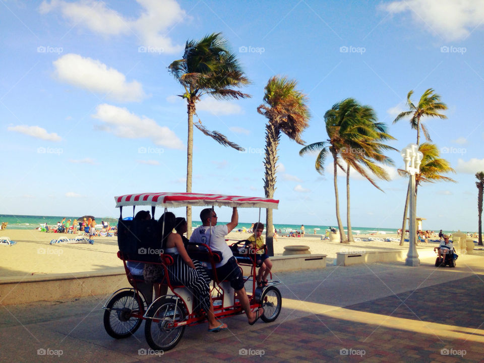 People riding pedal car at beach, Hollywood Florida, USA