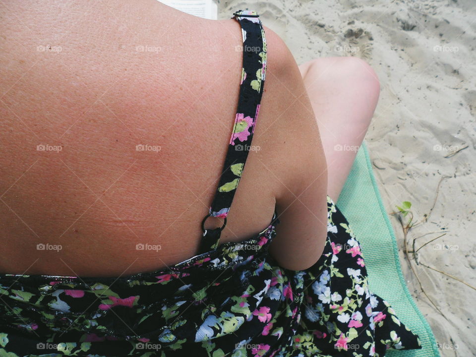 A girl in a sarafan sits on the sand