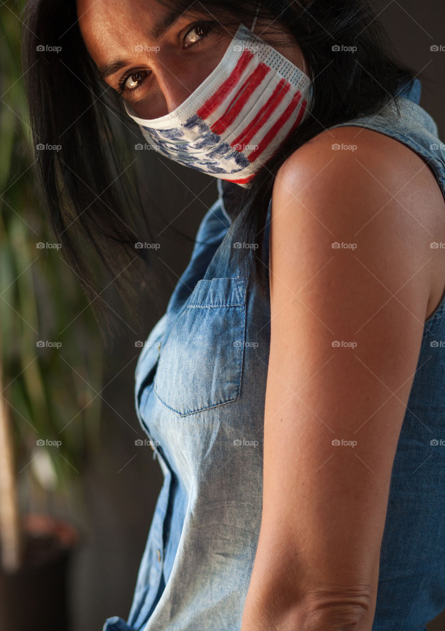 Beautiful brunette in a protective mask painted by the American flag.  Independence Day in America.  Flag.  Love.  A life.  The mask is made by hand