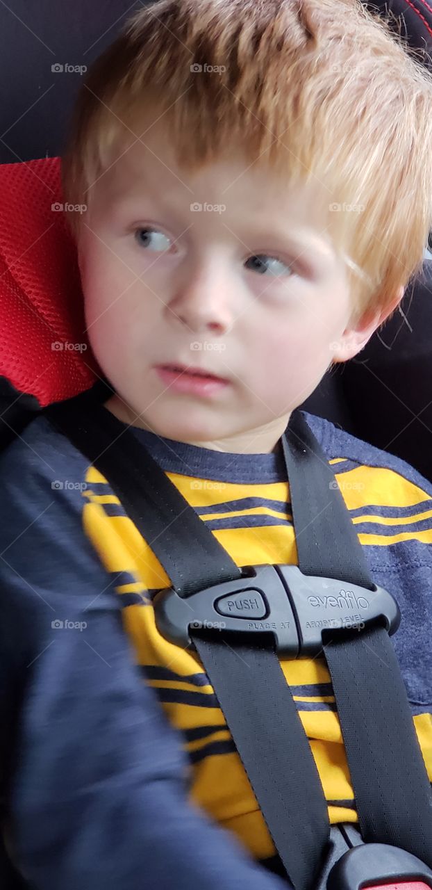 toddler boy sitting in car seat