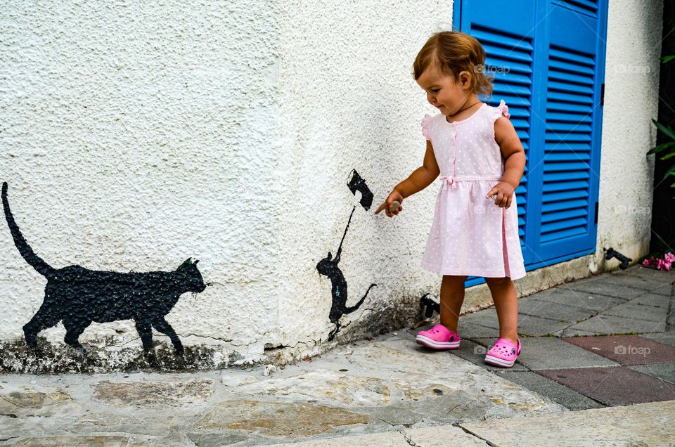 Walking in the old town, the baby found a cat and a mouse