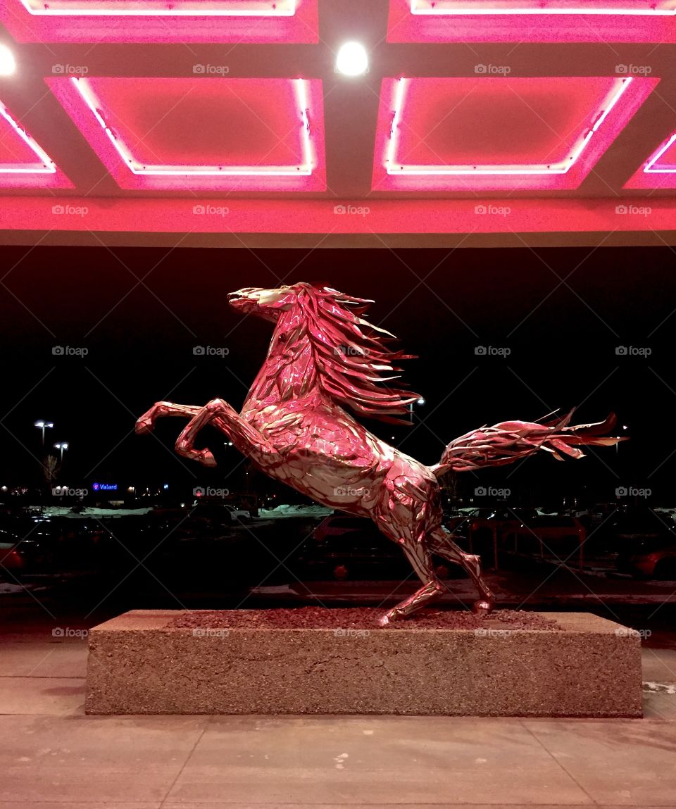 Horse statue under pink fluorescent lights