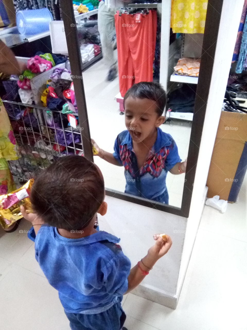 Little boy playing with mirror.