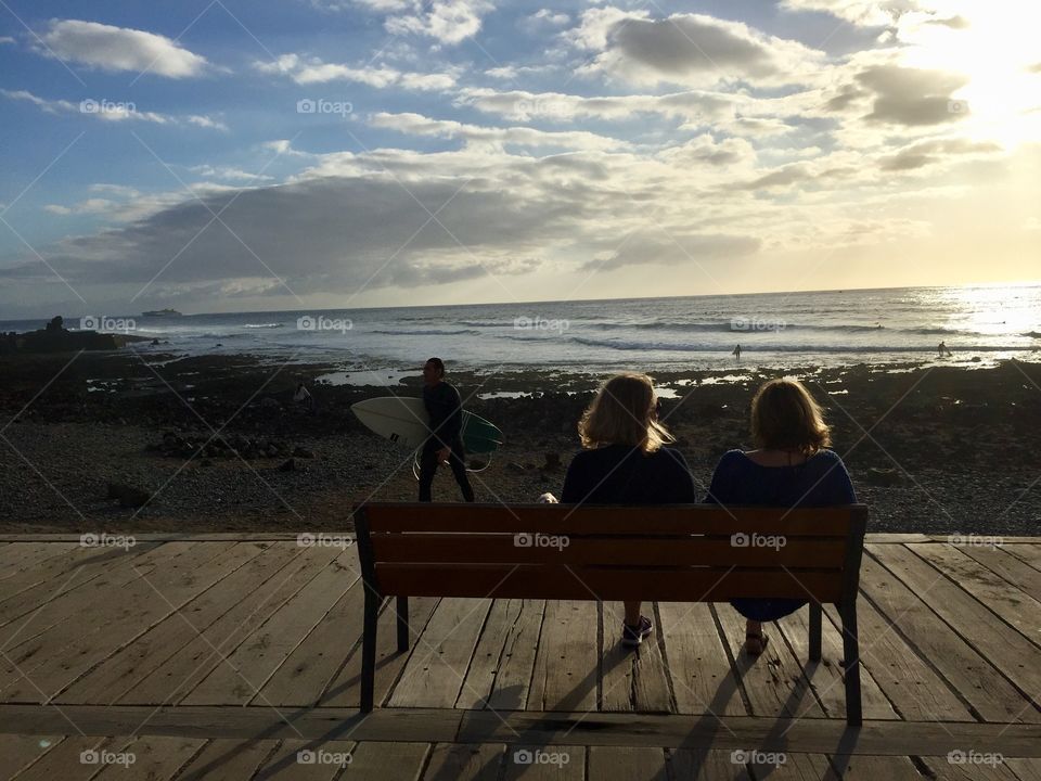 Women sitting on a bench looking out to sea
