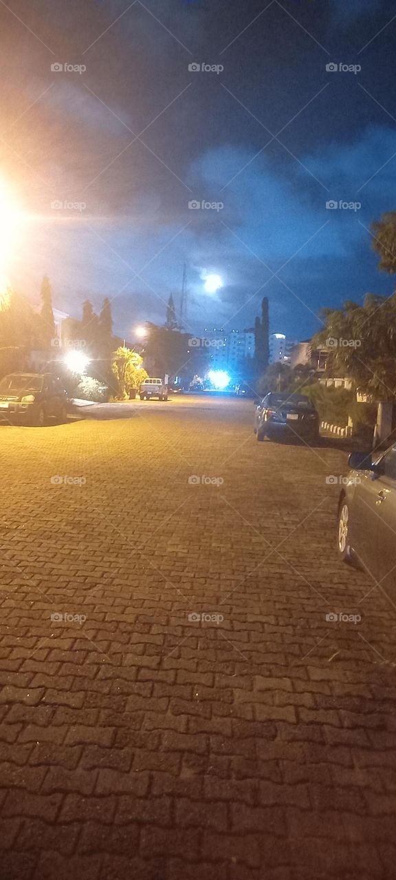Full moon, street lights forming an illusion of multiple moons with a blue moon on ground.Beautiful.