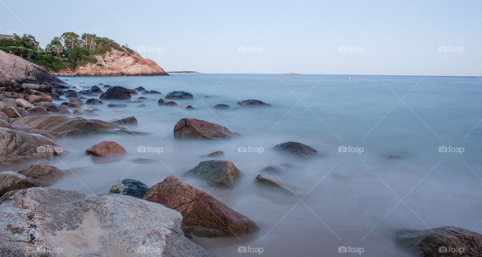 Long exposure landscape of the Atlantic Ocean's waves hitting the rocky New England coast.