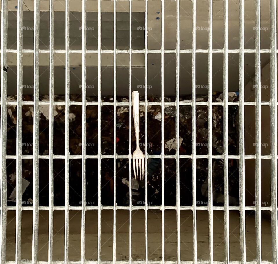 A stainless steel fork on a metal grate.