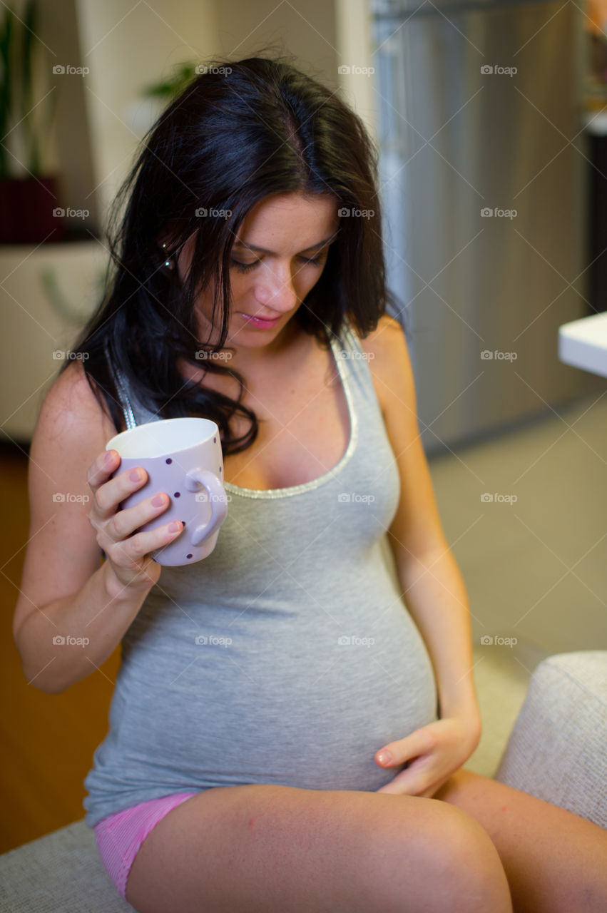 Pregnant woman with cup in his hands