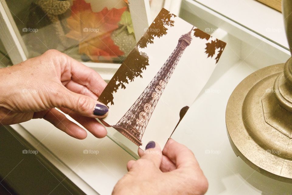 A woman looking at her old photo of when she went to Paris, France in 1989 when Paris hosted an Exposition Universelle (World’s Fair) to mark the 100 year anniversary of the French Revolution. The Eiffel Tower had a special 100 Ans light on the side!