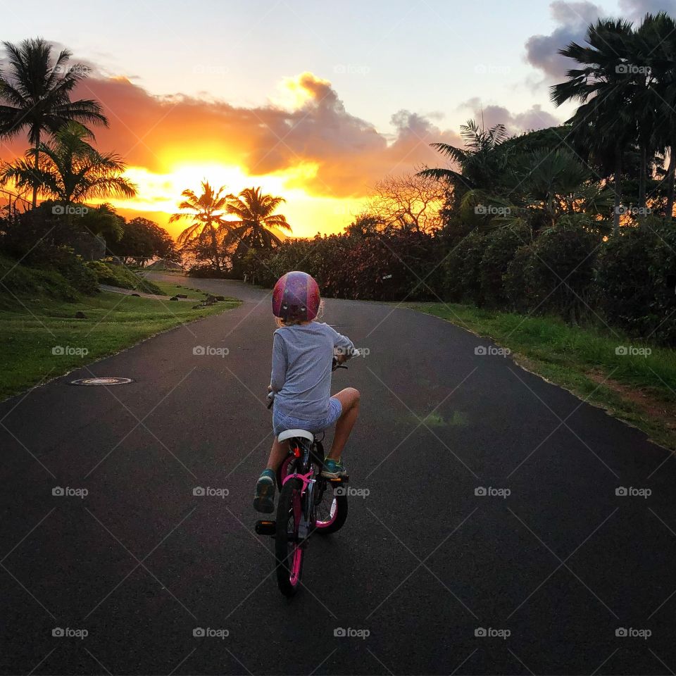 Little one riding bike into the sunset 