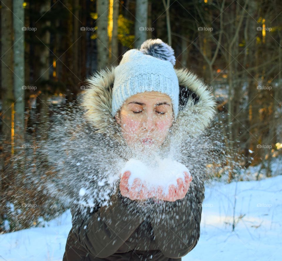 Close-up of a woman blowing snow