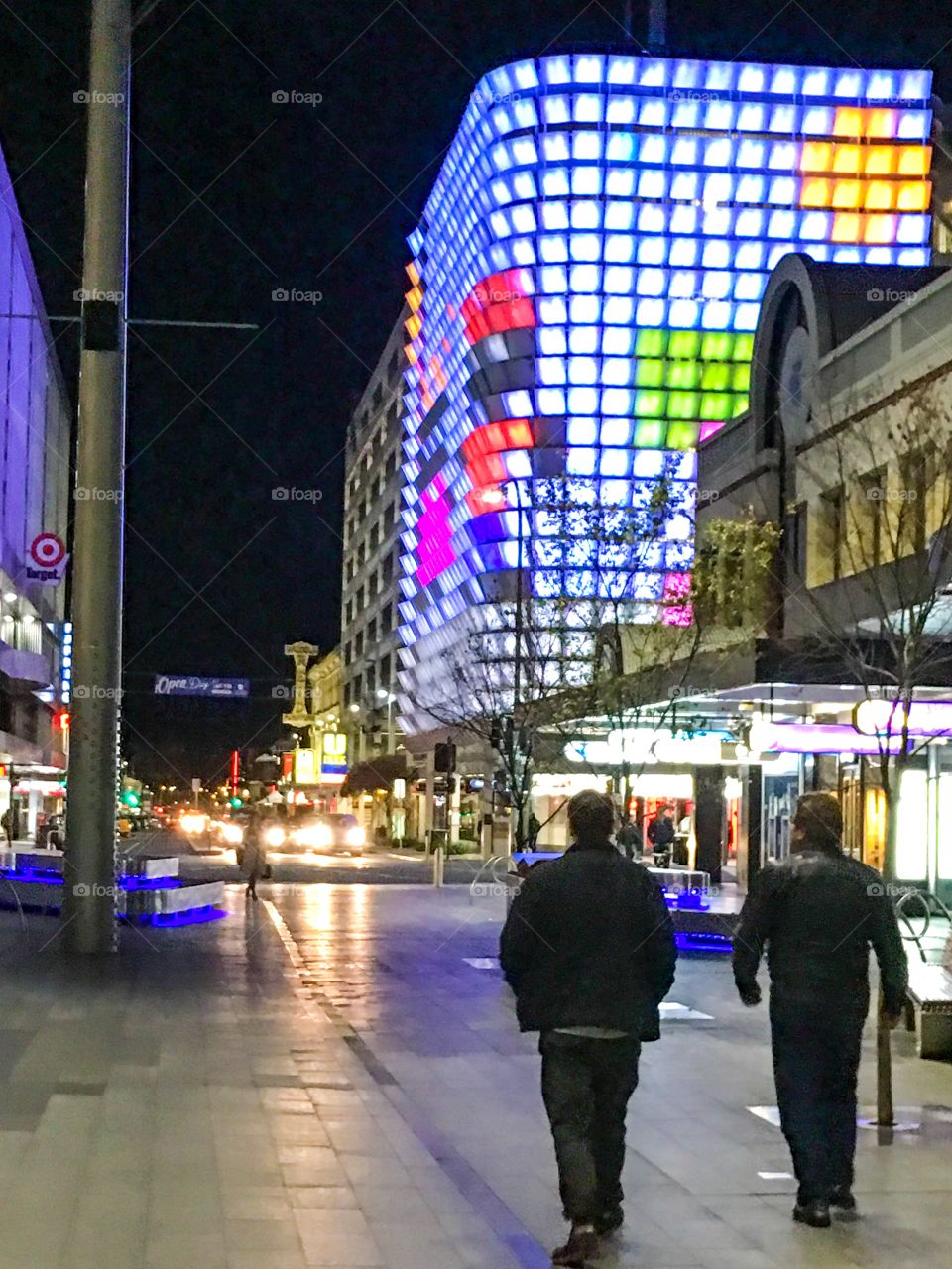 City life at night downtown Adelaide people walking neon lights