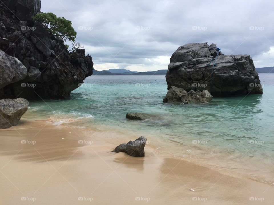 Big rocks on a white sand beach