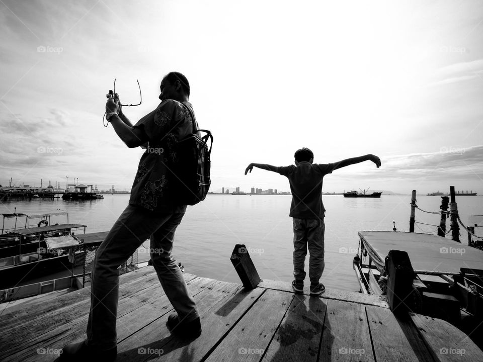 Tourist at waterfront jetty performing for the sake of instagrams