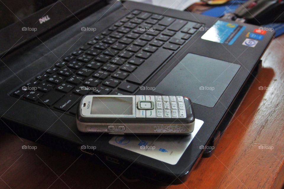 Old mobile phone on laptop