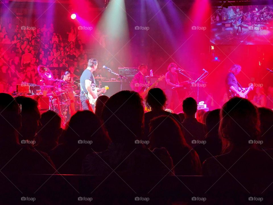 A pop band has the audience captivated by both the music and the brilliant light show