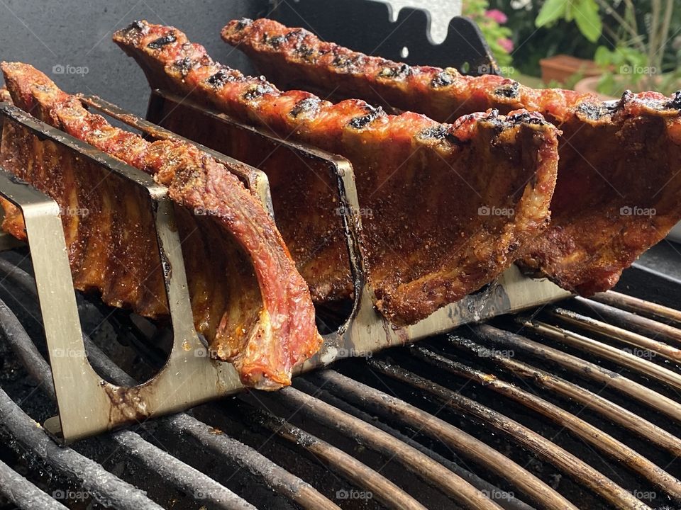 Spareribs on a barbecue in a rack