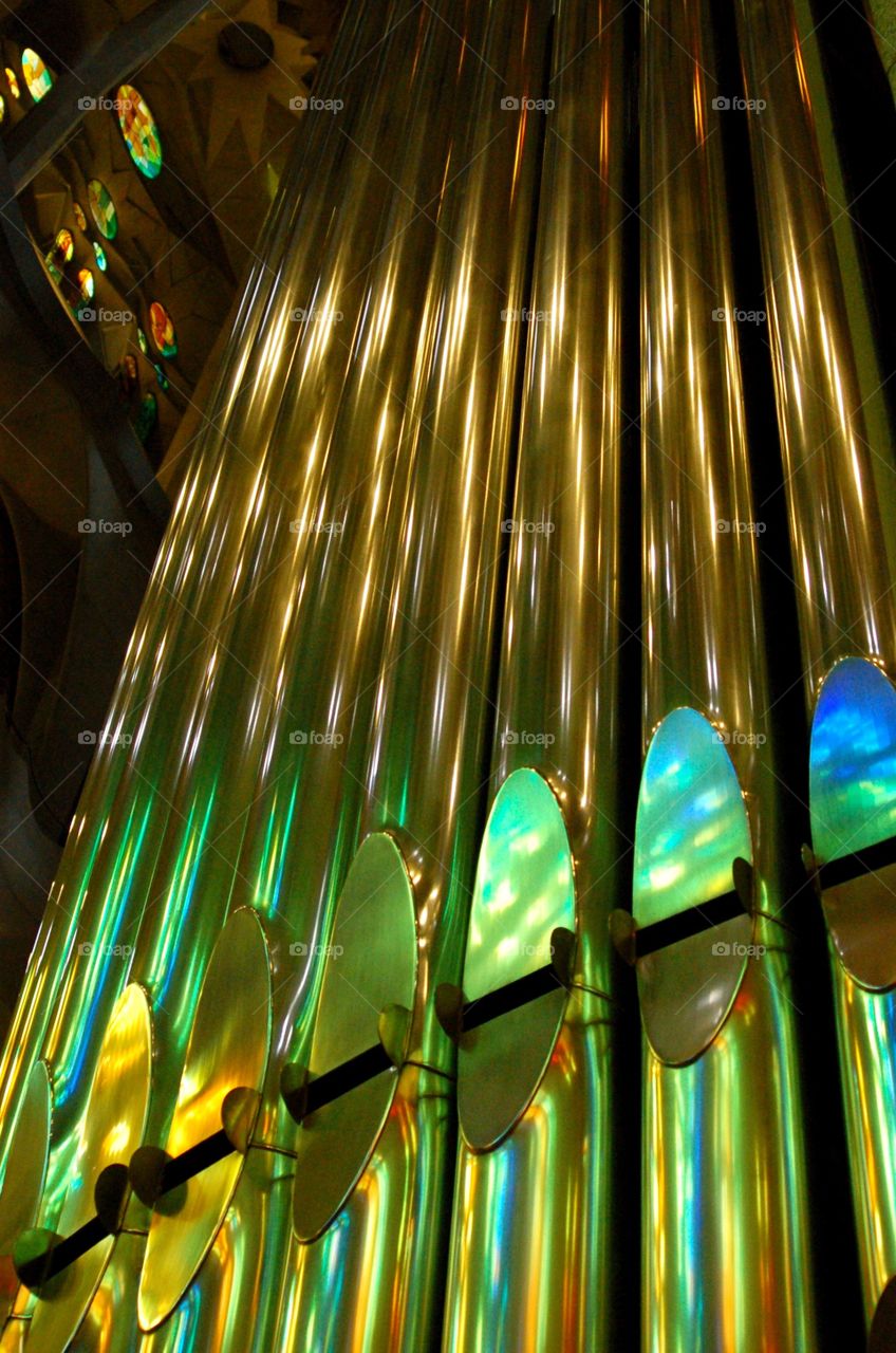 Organ pipes reflecting stained glass colors