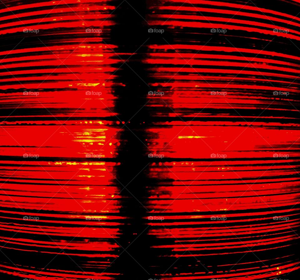 A red light shining through a stack of red CDs