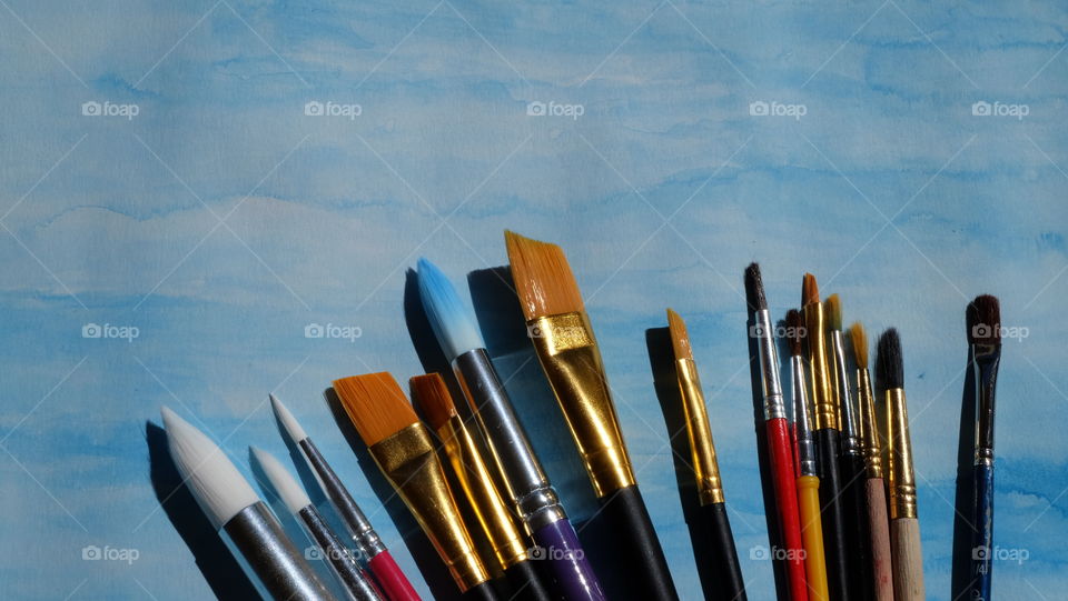 Paint brushes against a blue background
