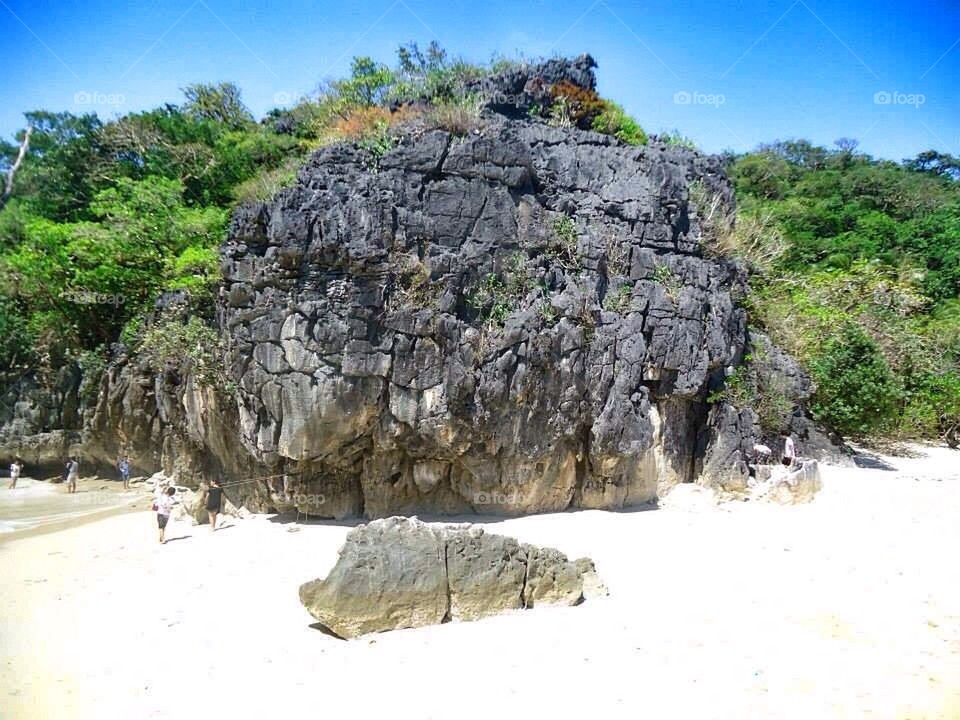 Big rock over white sand