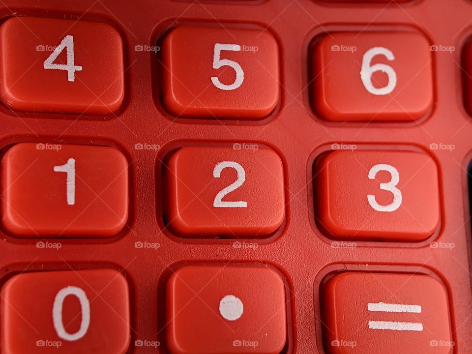 Closeup red calculator with rectangle shape button number.