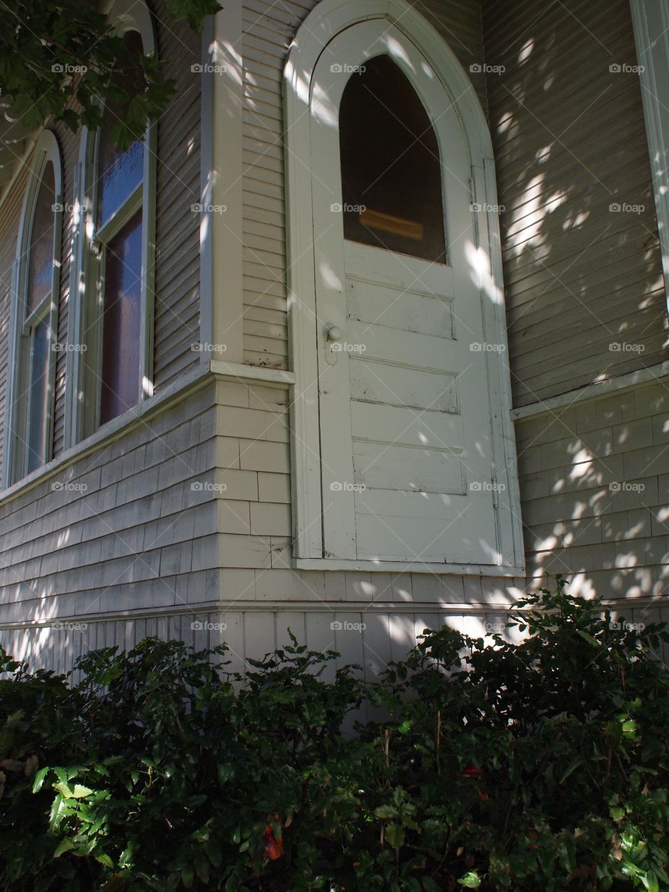 A door going nowhere except down into the bushes on an old church building in Central Oregon on a fall day. 