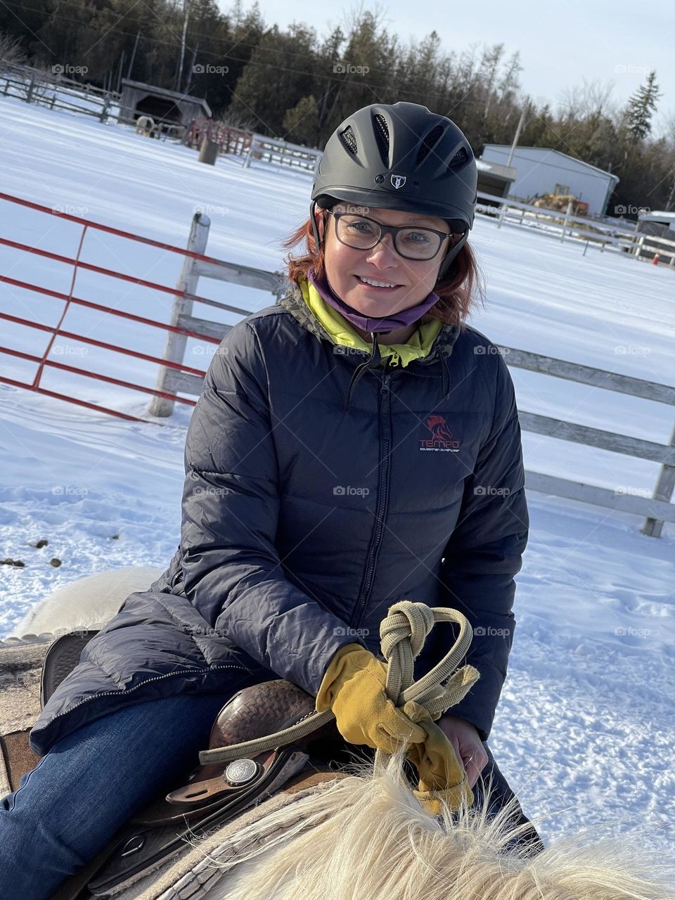 Girl with glasses riding a horse