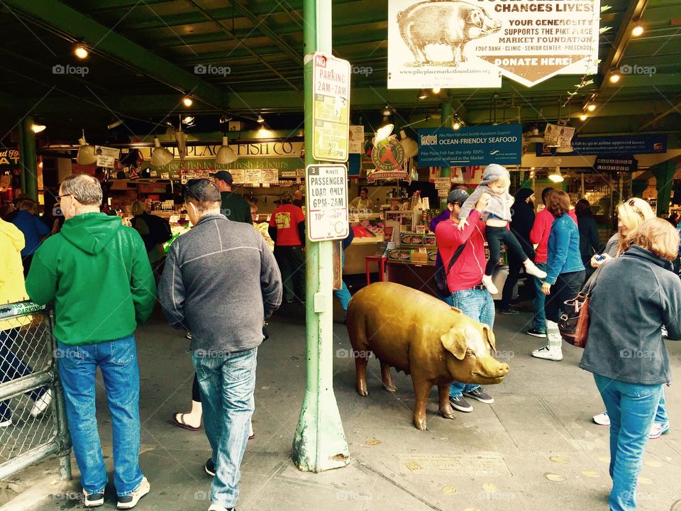 Pike Place Market Pig with father placing child on Pig