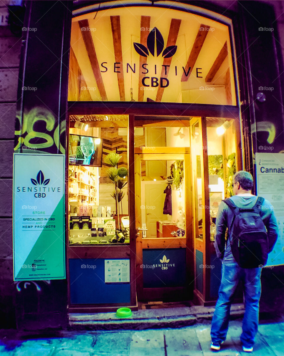 Potential customer cautiously views cannabis shop in Barcelona