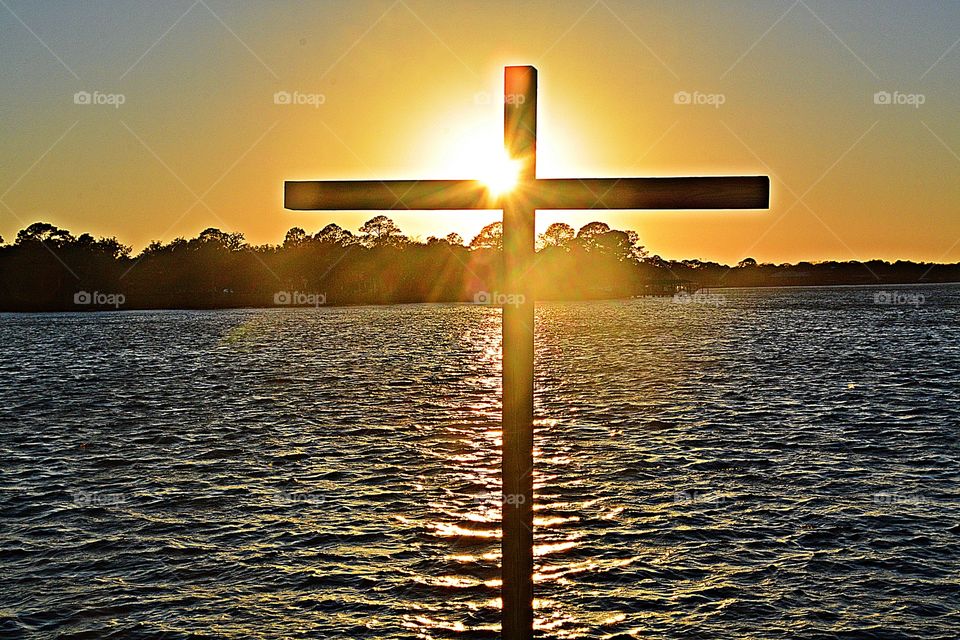 Sunrise and sunsets of USA - the old rugged cross still stands as the sun reflects off it and the waters surface